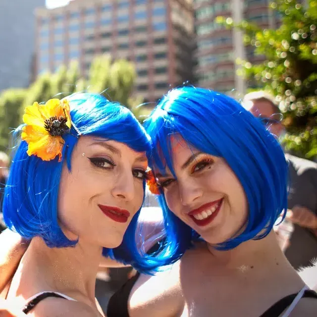 Duas mulheres 和 perucas azuis participam do San Francisco Pride.